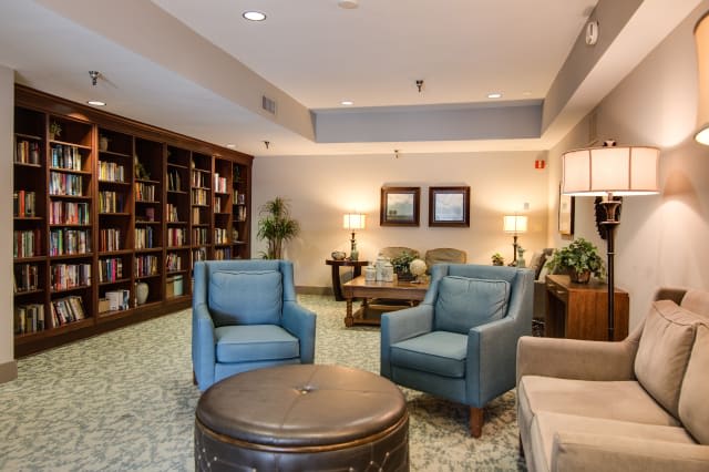 A cozy library area with armchairs and bookshelves, providing a comfortable reading space.