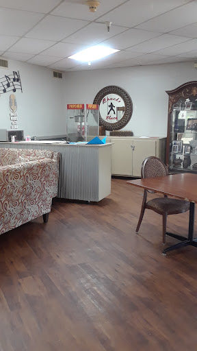 A cozy caf interior featuring a patterned sofa, wooden flooring, and a display case.