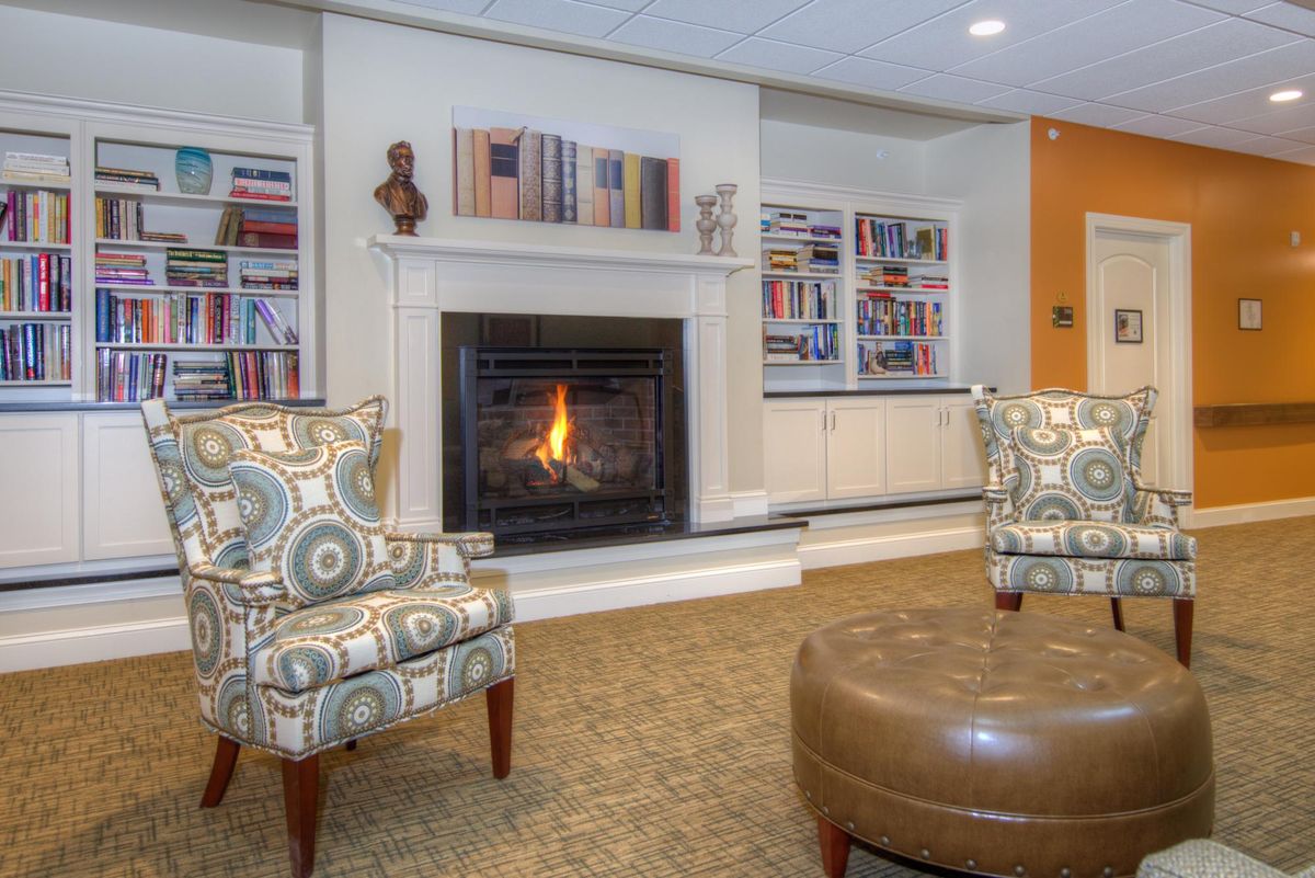 A cozy living room with a fireplace and bookshelves.