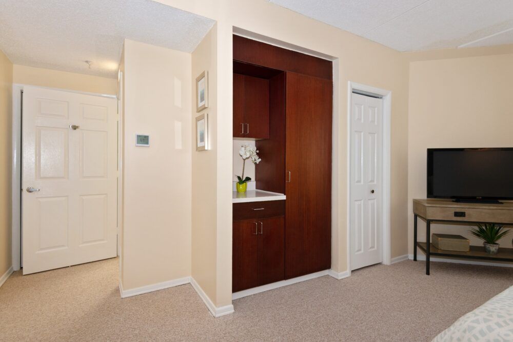 A cozy interior hallway with beige walls and a built-in wooden cabinet.
