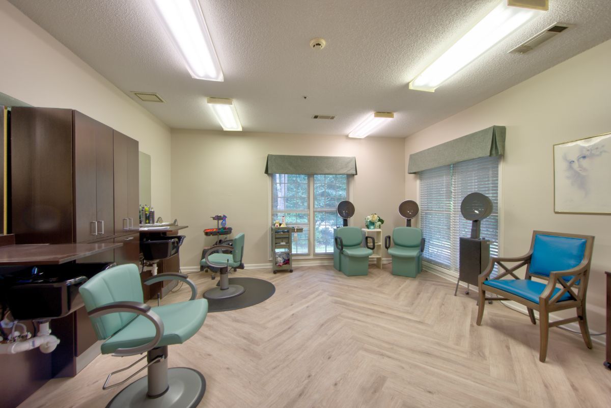 A spacious hair salon interior with styling chairs and hair dryers.