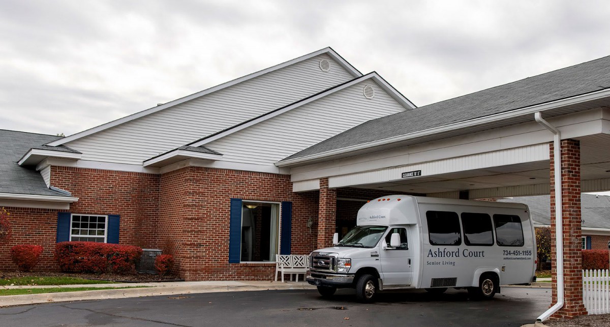 A van parked outside a brick building under a cloudy sky.