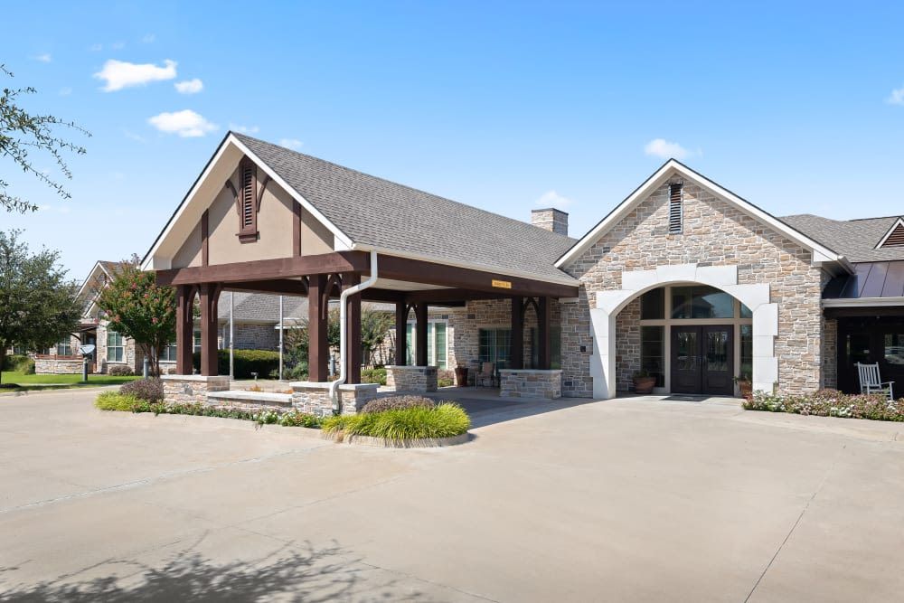 A modern building with a stone facade and a covered entrance.