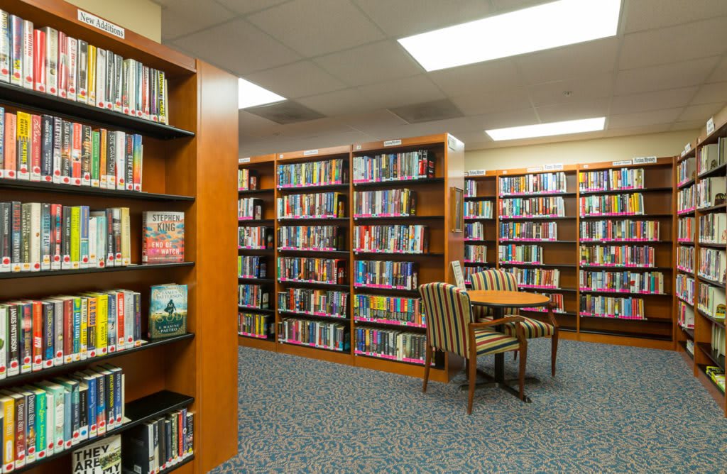 A library interior with bookshelves filled with books and a cozy reading area.