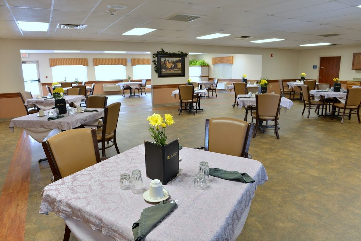 A spacious dining room with elegantly set tables and floral decorations.