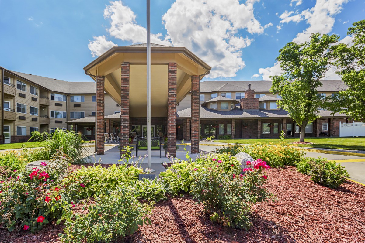 Front view of a building with landscaped gardens and a clear blue sky.