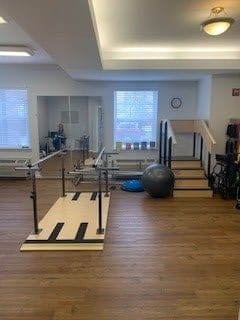 A physical therapy room equipped with parallel bars and exercise equipment.