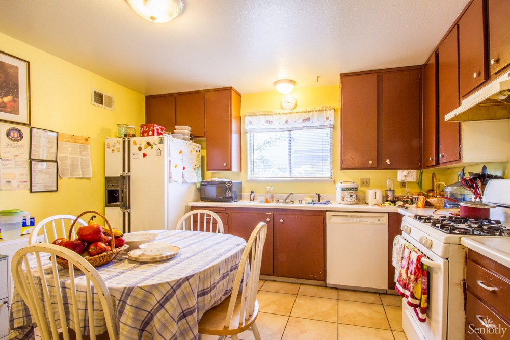 A cozy kitchen with wooden cabinets and a dining table set for two.