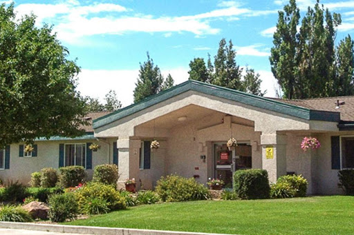 A charming residential house surrounded by well-maintained landscaping and trees.