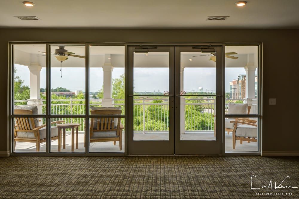 A cozy indoor seating area with a view of the patio and lush greenery beyond.