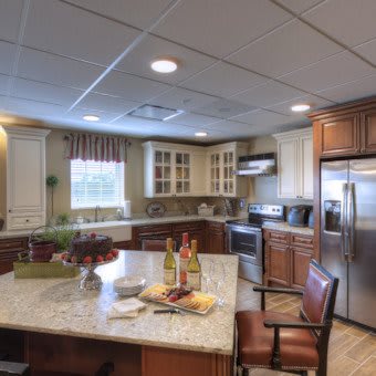 A modern kitchen with a central island, stainless steel appliances, and wooden cabinets.