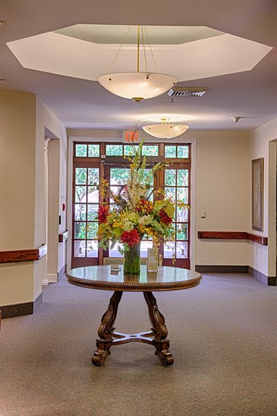 A beautifully decorated hallway with a table displaying a vase of vibrant flowers.