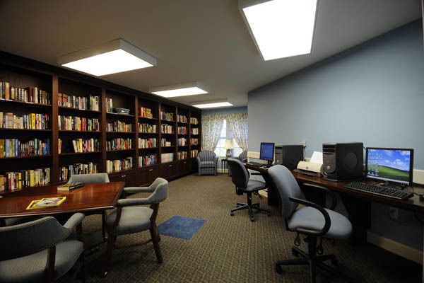 A quiet library space with bookshelves, computers, and seating area for study.