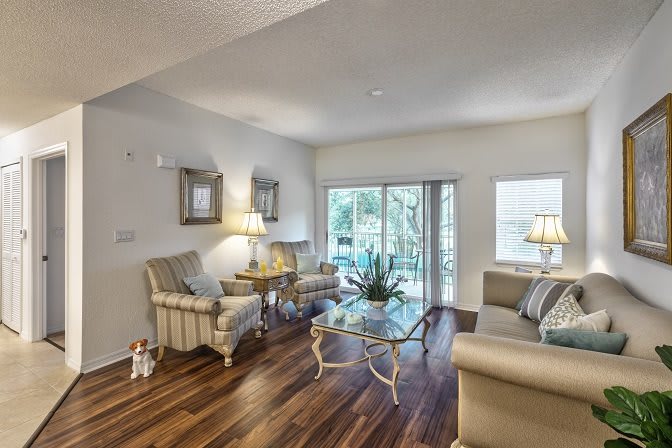 A cozy living room with elegant furniture and large windows offering natural light.