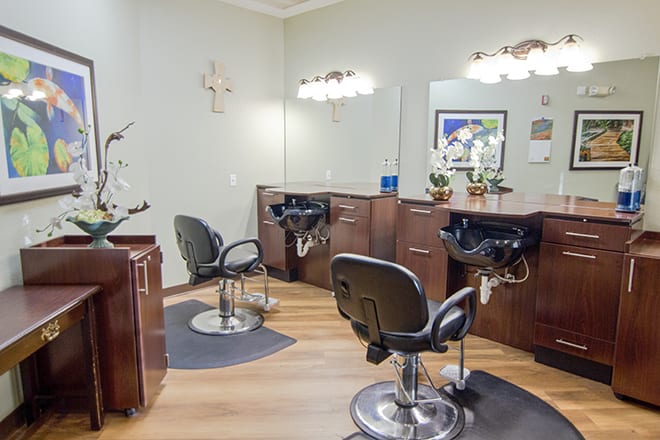 A modern hair salon interior featuring styling stations with chairs and mirrors.