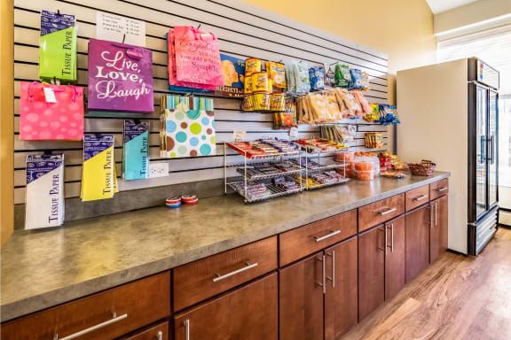 A store counter featuring shelves stocked with various snacks and colorful bags.