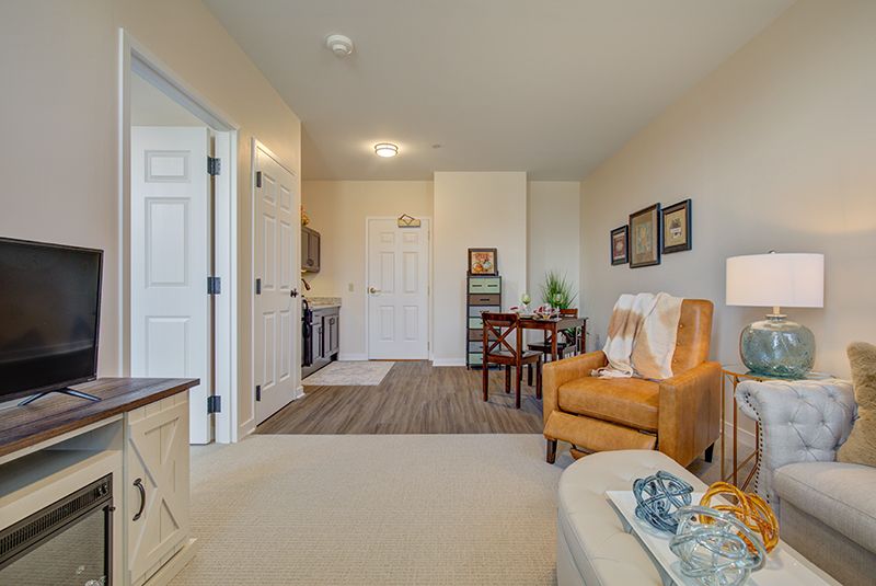 A cozy living room with modern decor, featuring a comfortable armchair and a small dining table.
