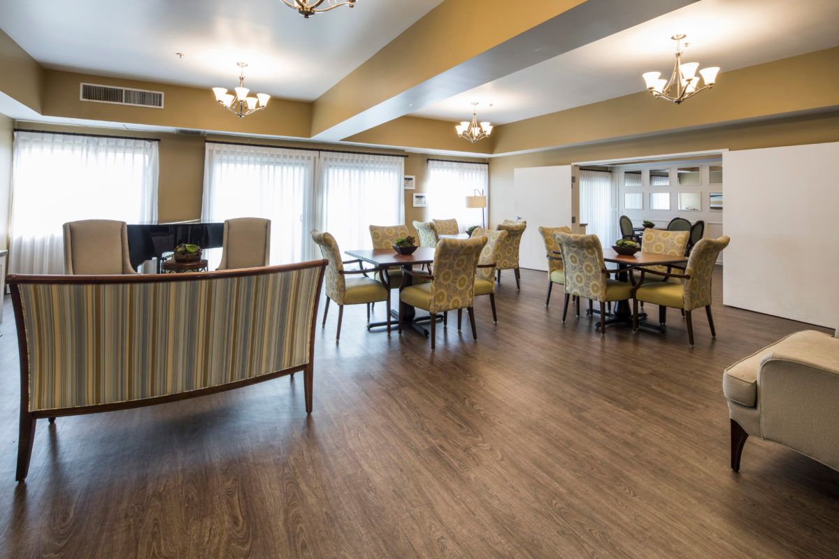 A spacious dining area with elegant chandeliers and comfortable seating.