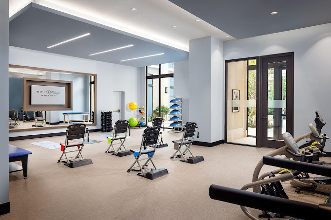 A modern gym with exercise equipment arranged neatly in a spacious workout area.