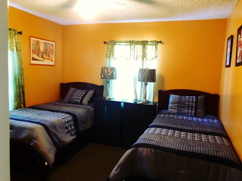 A cozy bedroom with twin beds and warm orange walls.