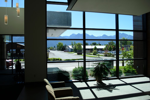 A bright lobby with large windows showcasing a scenic view of the mountains outside.