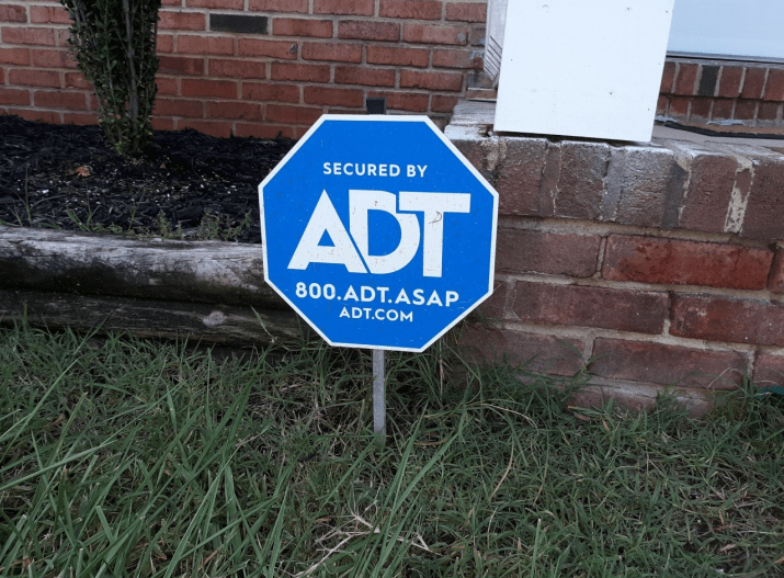 A yard sign indicating ADT home security system.