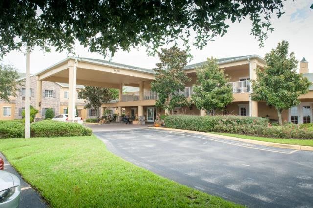 A hotel building with a covered entrance and landscaped surroundings.