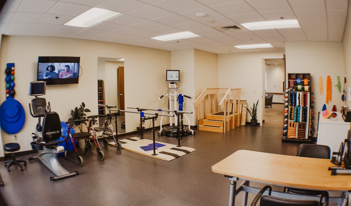 A spacious rehabilitation center equipped with various exercise tools and a small staircase for physical therapy exercises.