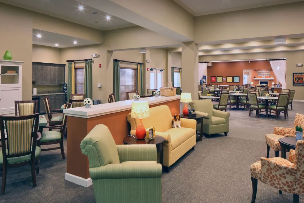A comfortable lounge area with armchairs, sofas, and warm lighting.