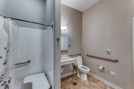 A spacious and accessible bathroom featuring a shower, toilet, and sink.