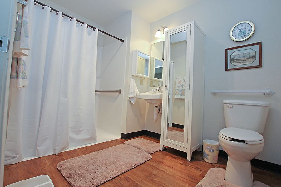 A modern bathroom with a shower, cabinet, and various amenities.
