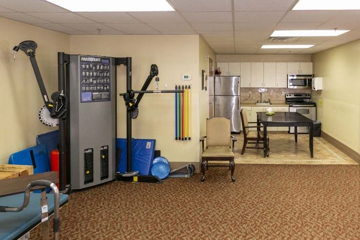 A small fitness area with exercise equipment and a kitchen corner.