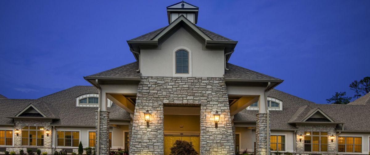 A stone facade building with illuminated entrance during the evening.