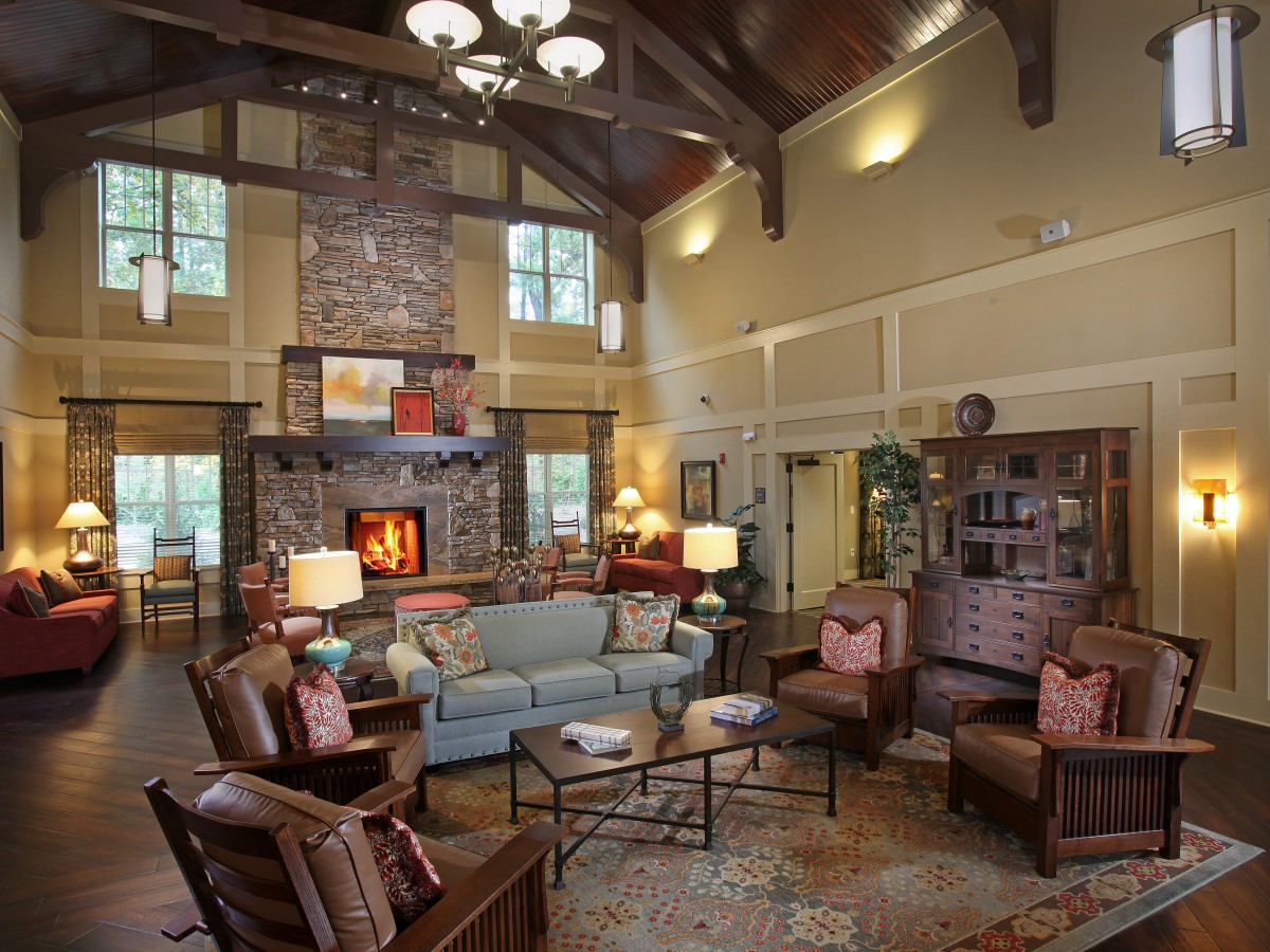 A cozy rustic living room with a stone fireplace and wooden beams.