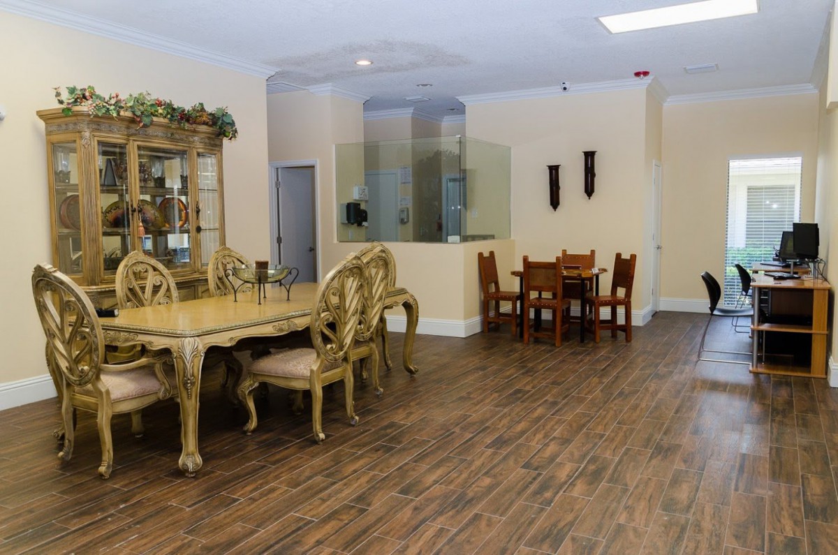 A spacious dining room with elegant furniture and wooden flooring.