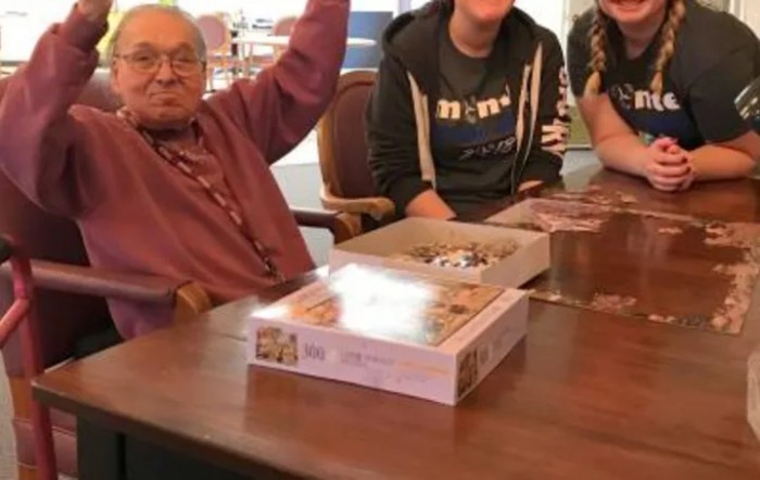 A group of people sitting around a table with a board game.