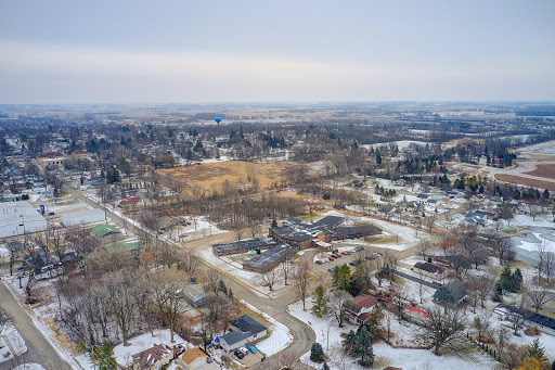 An aerial view of a suburban area blanketed in snow, showcasing the quiet beauty of winter in a small town.