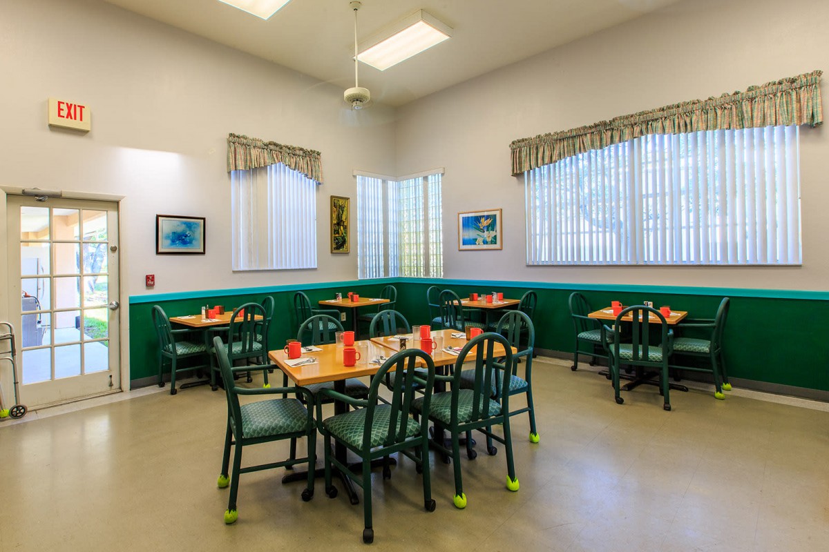 A cozy dining area with green accents and neatly arranged tables.
