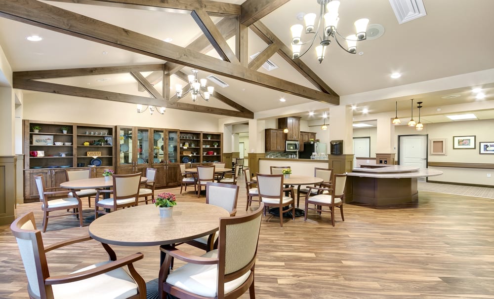A modern dining area with wooden beams, elegant chandeliers, and comfortable seating arrangements.