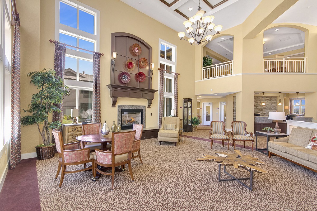 A spacious and elegantly designed lobby area with comfortable seating, a fireplace, and abundant natural light.
