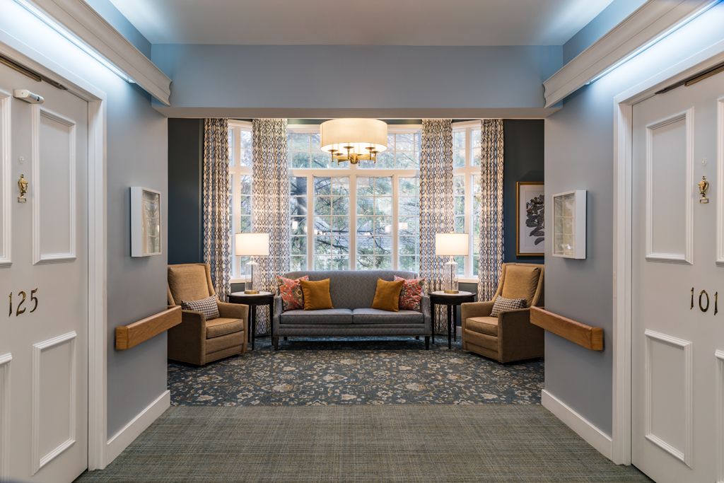 A cozy living room with a sofa, armchairs, and a chandelier illuminating the space.