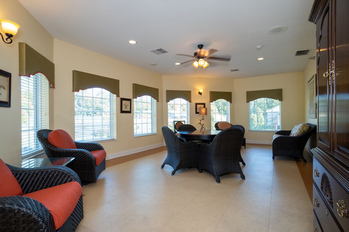 A cozy living room with wicker furniture and large windows.