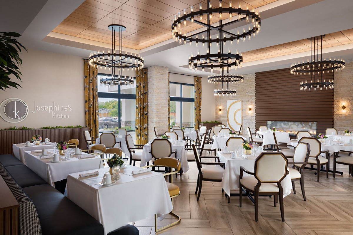Elegant restaurant dining area with chandeliers and white tablecloths.