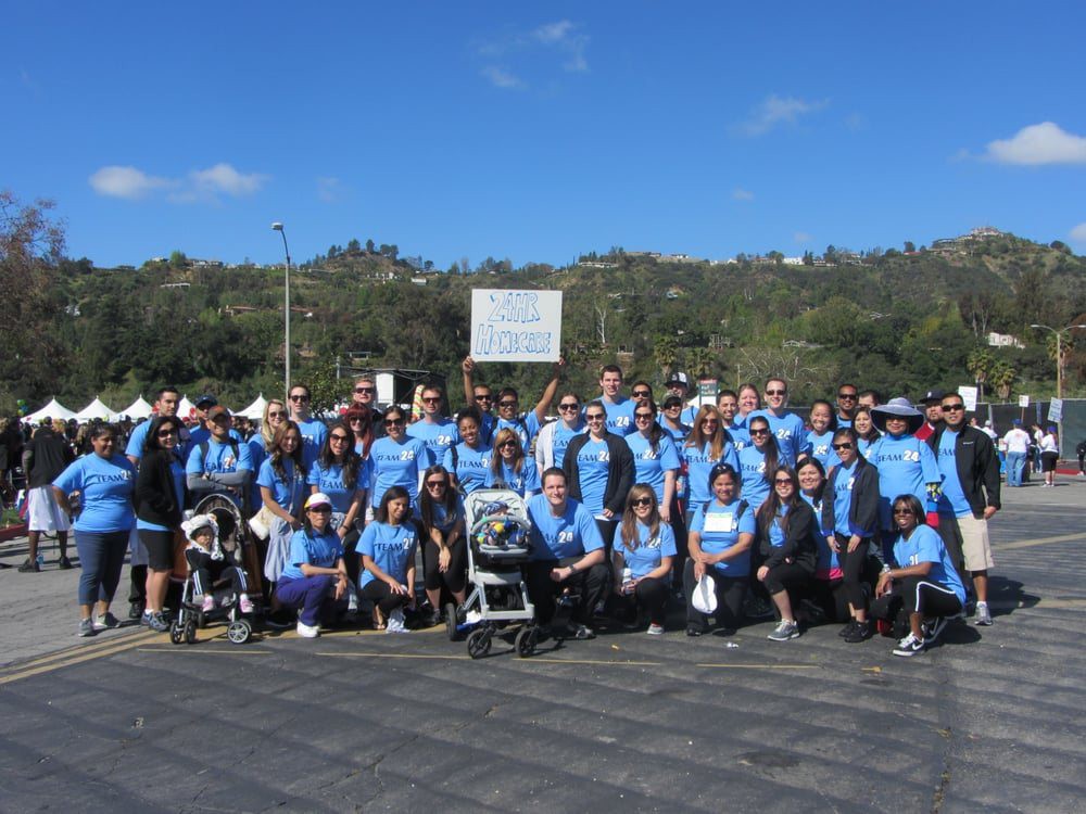 A large group of people wearing blue shirts gathered outdoors for an event.