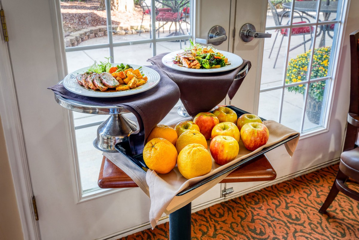 A table with plates of food and a display of fresh apples.