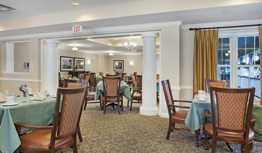 A spacious dining room with elegantly set tables and chairs.