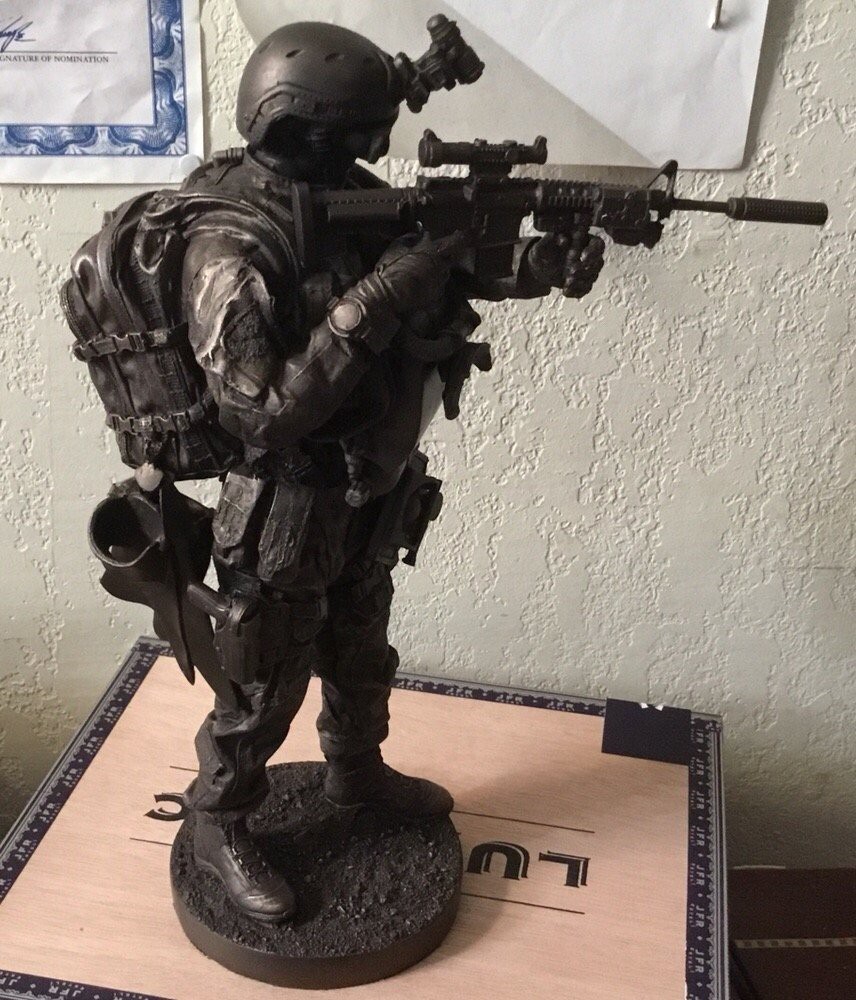 A detailed statue of a soldier in full military gear holding a rifle.