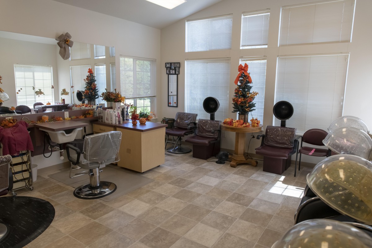 A cozy hair salon interior with chairs, mirrors, and festive fall decorations.