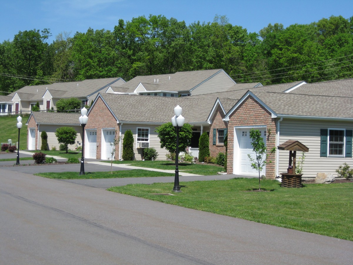 A peaceful suburban neighborhood with brick houses and well-maintained lawns.