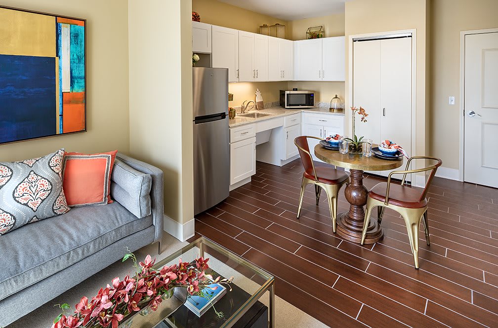 A cozy apartment interior featuring a modern kitchen and inviting living area with a dining table.